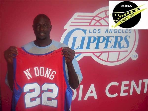 Boniface N'Dong, premier basketteur senegalais a offrir son maillot des Clippers pour le Musee du Sport.